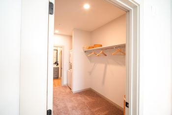 a walk in closet with shelves and a door to a bathroom at Preston Ridge, Cary, 27513